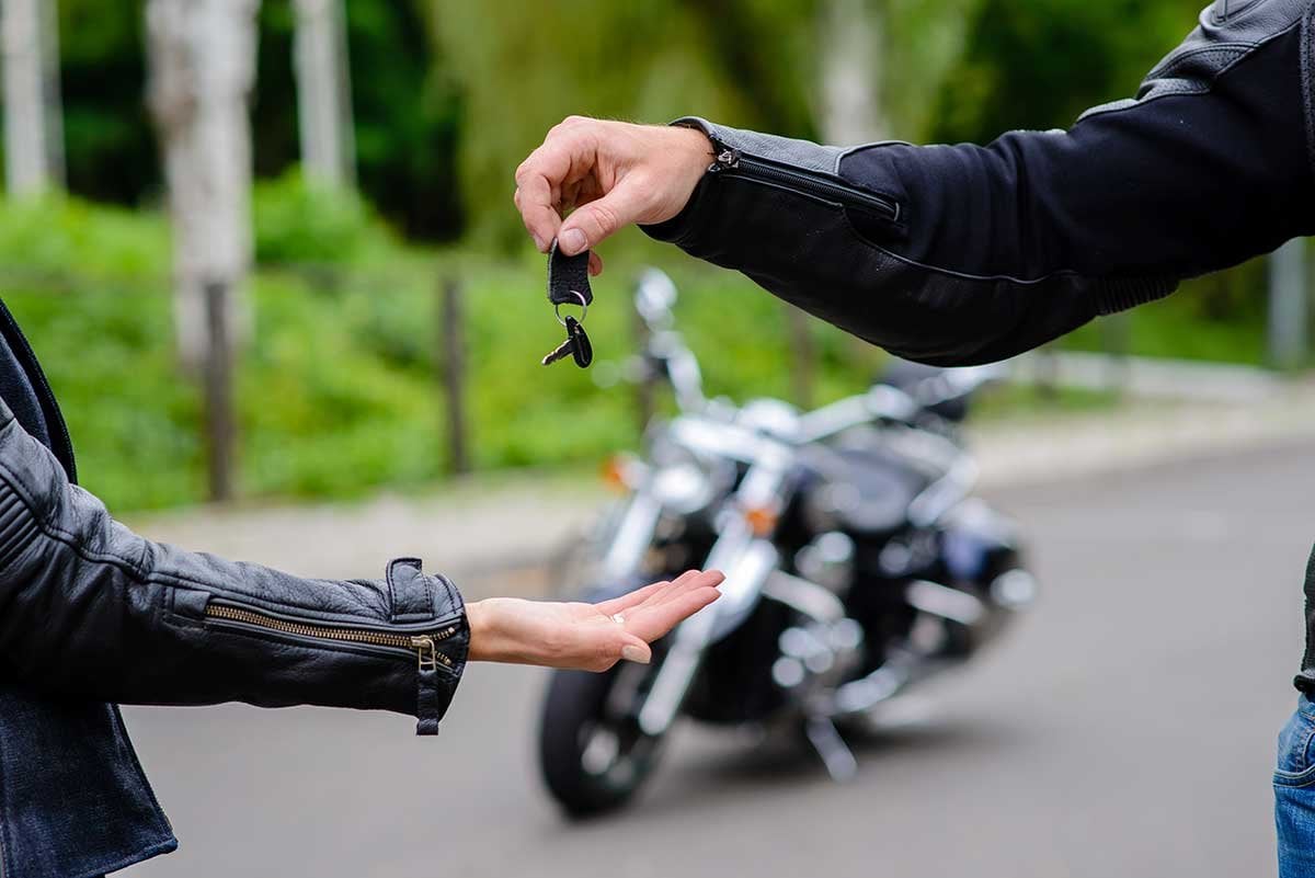 Motorcycle Rider Giving Keys to Another Rider