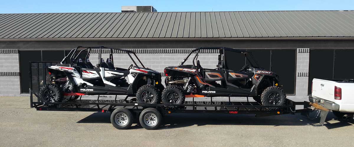 utvs loaded on a trailer attached to a white truck