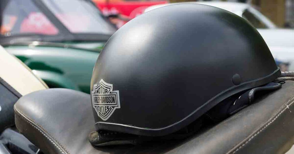 Motorcycle half helmet laying on the seat of a cruiser style motorcycle.