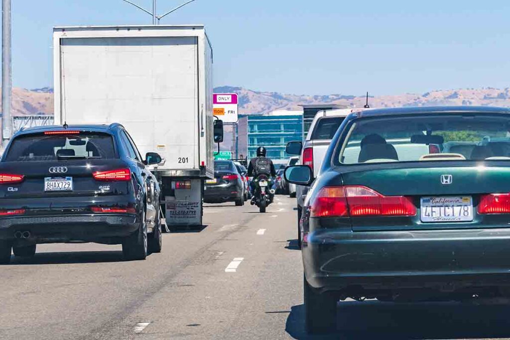 Motorcycle splitting lanes during heavy traffic on one of the freeways crossing Silicon Valley.